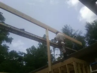 Carpenter setting a ridge beam over a new addition frame — Ice Dam Removal by Roofing Brothers in Russell Springs