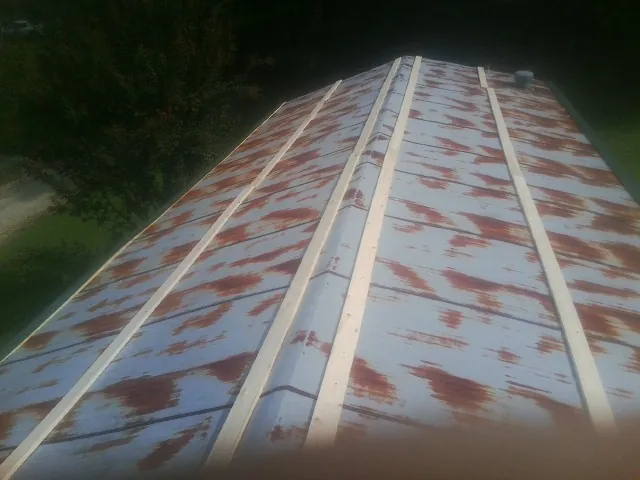 Rusted metal roof panels with new wood purlins before replacement — Storm Damage Roof Repair in Russell Springs by Roofing Brothers