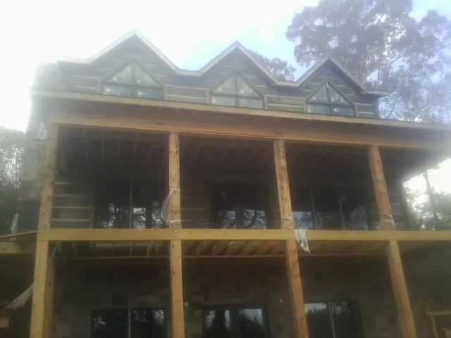 Dormers and porch framing on a large log home under construction — Roof Coating work by our crew in Russell Springs