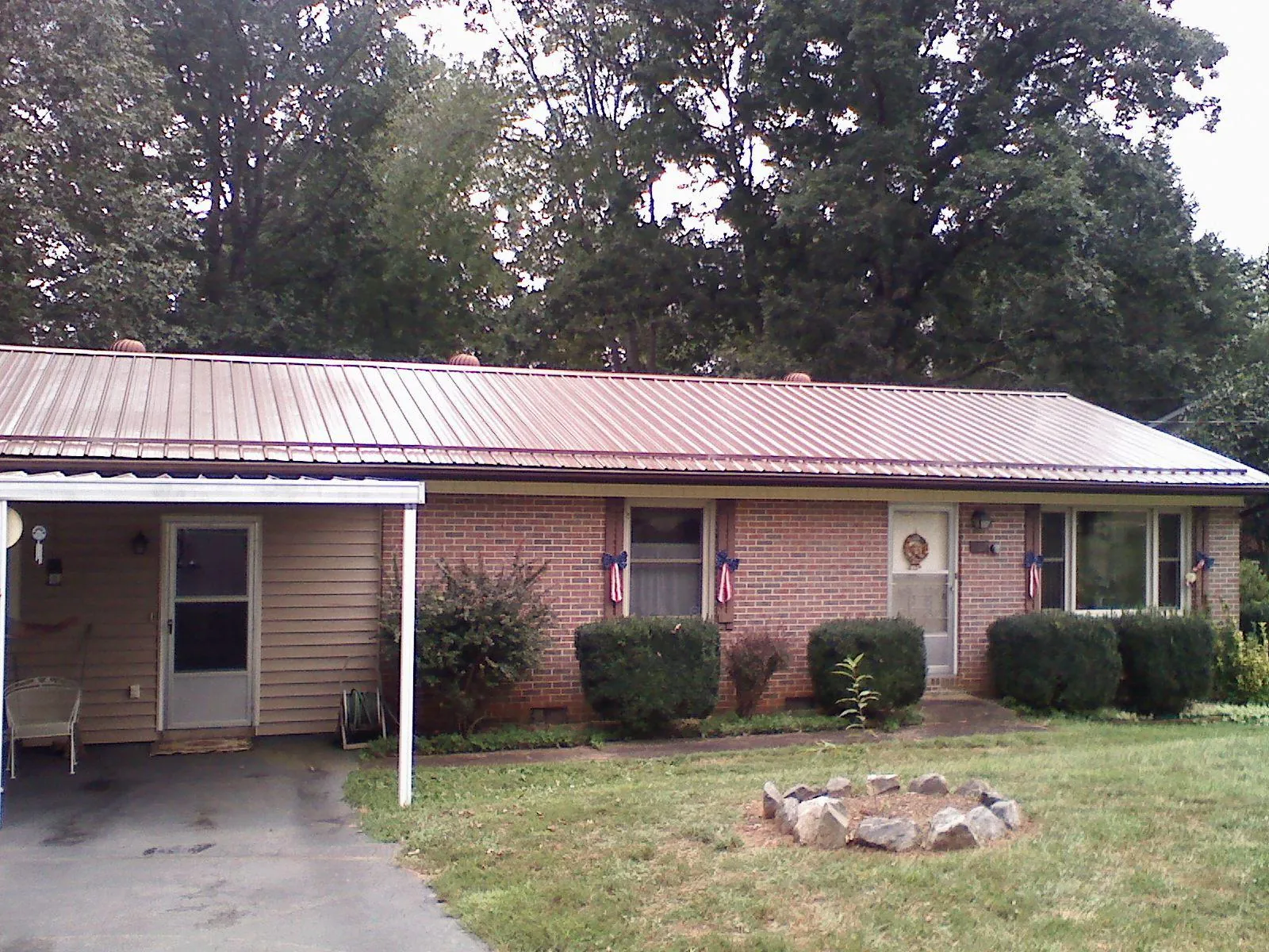 Bronze metal roof and carport on a brick ranch home — Roof Repair work by our crew in Russell Springs